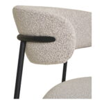 Close-up van de Dining chair, bouclé, zand met zwarte poten, HN1267 (set van 2) met een gestructureerde lichtbeige rugleuning en zitting van bouclé stof, ondersteund door een strak zwart metalen frame. De afbeelding benadrukt de gebogen rugleuning en bovenkant.