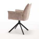 De Eetkamerstoel Dani Velvet Beige is een moderne beige fluwelen eetkamerstoel met een hoge rugleuning, schuine armleuningen en naar buiten geplaatste zwarte metalen poten, tegen een witte achtergrond.