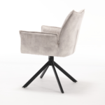 De Eetkamerstoel Dani | Velvet Champagne (set van 2) bestaat uit moderne stoelen met een afwerking van champagne fluweel, zwarte metalen poten en een draaivoet, stijlvol tegen een effen witte achtergrond.