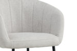 Een close-up van de Stoel 'Sevilla' Stof Beige, met lichtbeige bekleding, een gebogen rugleuning met verticaal stiksel en zwarte metalen poten, tegen een witte achtergrond. De stoelen worden verkocht in sets van 2 per doos.