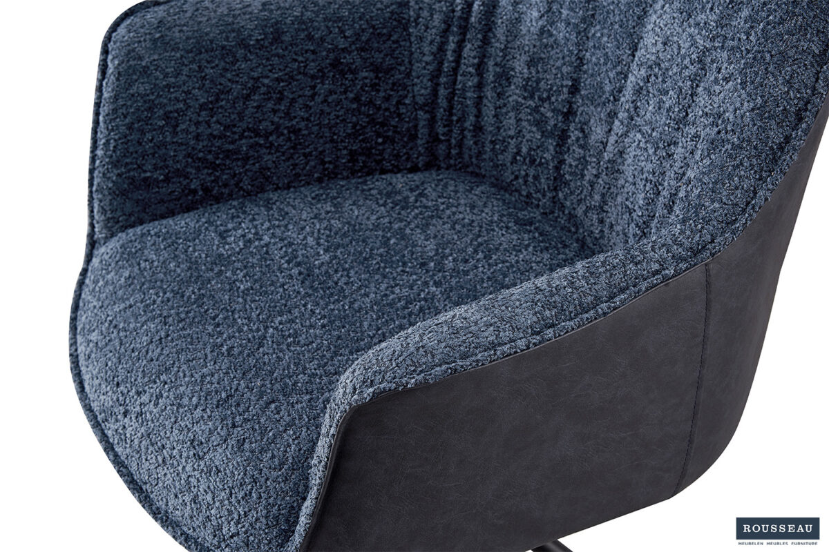 Een close-up van de SALE - Eetkamerstoel 'Lucie' Bouclé Blauw Vloerkleed PU Blauw (2 per doos), waarop de blauwe bouclé stof met structuur op de zitting en rugleuning te zien is, met glad blauw PU aan de zijkanten. Het Rousseau merklogo staat rechtsonder.