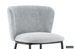 De Stoel 'Arthur' Stof Ote Belfast 41 Lichtgrijs heeft een moderne afgeronde rugleuning en zitting in lichtgrijze stof, met slanke zwart metalen poten. Twee stoelen per doos. Het Rousseau merklogo staat rechtsonder.