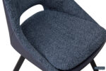 Close-up van het SALE - Eetkamerstoel 'Filou' Bouclé Blauw Vloerkleed PU Blauw, met zacht blauwe structuurbekleding, een gebogen rugleuning, minimalistisch ontwerp en zwarte houten poten. Rousbeau-logo zichtbaar in de rechterbenedenhoek.