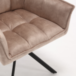 Een close-up van de Eetkamerstoel Dani Velvet Beige stoel, met zijn moderne beige fluwelen bekleding, pluche getufte zitting en rugleuning en zwarte metalen poten tegen een witte achtergrond.