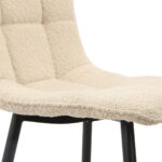 Close-up van Eetkamerstoel Yerevan - Bouclé Taupe, met een zitting van beige bouclé stof met een getuft roosterpatroon en zwarte metalen poten voor een moderne stijl en comfort.