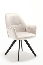 De Eetkamerstoel Nova Champagne is een moderne, lichtbeige gestoffeerde fauteuil met een gecapitonneerde zitting en rugleuning, met schuine zwarte metalen poten, tegen een witte achtergrond.