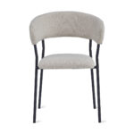 De Eetkamerstoel Ava - Bouclé Taupe heeft een zachte, licht taupe bouclé gestoffeerde zitting met een gebogen rugleuning en een open ruimte ontwerp, ondersteund door slanke zwart metalen poten voor een moderne uitstraling.