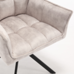 Een close-up van de Eetkamerstoel Dani | Velvet Champagne (set van 2), met licht champagne fluwelen bekleding en schuine zwarte metalen poten, tegen een effen witte achtergrond.