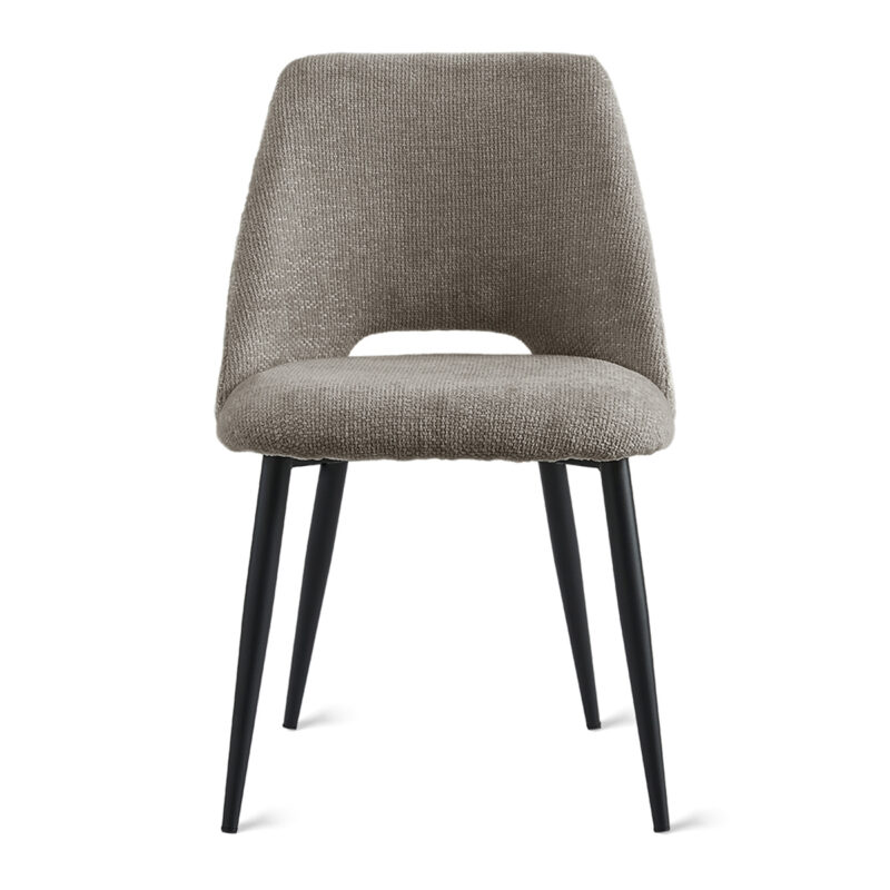 De Eetkamerstoel Monta - Taupe is een moderne eetkamerstoel met een gestructureerde taupe bekleding, een gebogen rugleuning met een kleine uitsparing en vier slanke zwarte metalen poten, tegen een witte achtergrond.