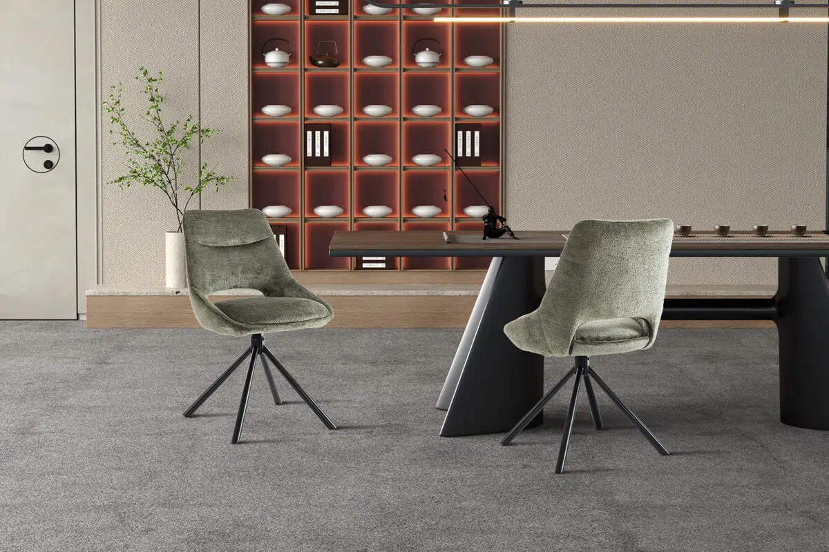 Twee groene eetkamerstoelen met een moderne tafel in een interieur met een neutrale kleurstelling.