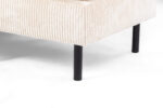 Close-up van de hoek van de 3-zits hoekbank rechts, stof Lincoln 03, RIB460 beige, met beige ribfluwelen bekleding met verticale ribbels en zwarte metalen poten tegen een witte achtergrond.