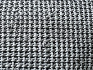 Close-up van een strakgeweven meubelstof die krasbestendig is tegen kattenklauwen