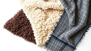 Drie verschillende soorten boucle-stof in beige, bruin en een geruit patroon op een witte achtergrond.