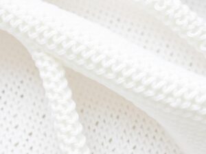 Close-up van witte boucle stof met zichtbare lusjes en textuur.