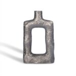 De Vaas Langwerpig Zilver is een rechthoekige, holle metalen vaas met een ruw gestructureerd oppervlak en een korte cilindrische hals, rechtopstaand op een witte achtergrond.