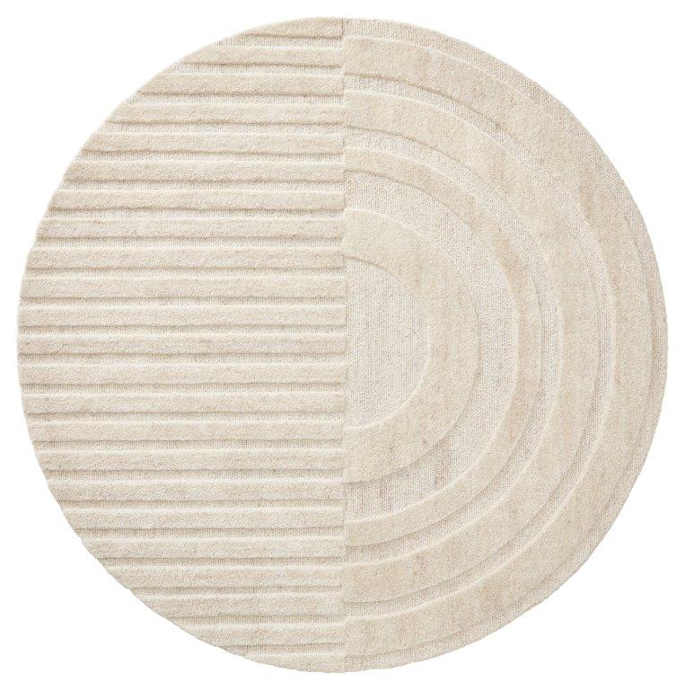 De Monza Girare 815 Light Grey ø200 is een rond, lichtgrijs tapijt met twee unieke texturen: de ene helft heeft horizontale ribbels, terwijl de andere helft concentrische ronde ribbels heeft.