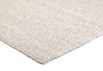 Close-up van de hoek van het tapijt Donna Cloud White 815 200x300 met een grof, kiezelachtig oppervlak in gebroken wit.