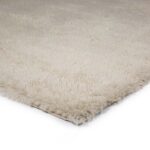 Een close-up van het Merano Silver 012 170x230 tapijt, met een zachte, pluche textuur en dikke pool in een crèmekleurig shagdesign, getoond vanuit een hoekperspectief tegen een witte achtergrond.