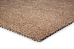 Een close-up van het rechthoekige vloerkleed Rome Beige 02 200x300 op een wit oppervlak, met de nadruk op het bruine structuurweefsel en de afgewerkte rand.