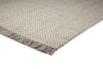 Een close-up van het Burano White Grey 001-367 200x300 tapijt, met een lichtbeige structuur met kleine ronde knopen en korte franjes aan één rand, tegen een witte achtergrond.
