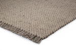 Een close-up van het Burano Light Grey 616-618 vloerkleed (170x230), met een geweven structuurpatroon en franjes aan de randen, tegen een witte achtergrond.