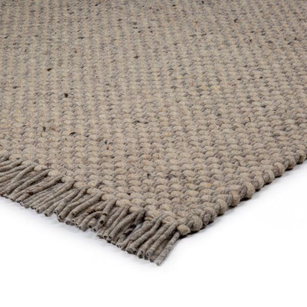 Een close-up van het Burano Light Grey 616-618 vloerkleed (170x230), met een geweven structuurpatroon en franjes aan de randen, tegen een witte achtergrond.