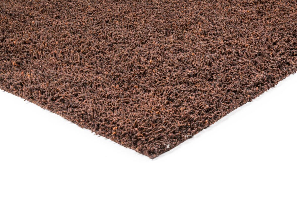 Close-up van de hoek van het Berbero Lungo Natural Beige 522 (200x300) tapijt op een witte achtergrond, waarbij de dikke, rafelige vezels met textuur worden benadrukt.