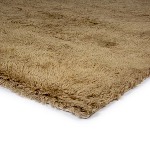 Een close-up van het Merano Beige 002 170x230 vloerkleed toont de zachte, dikke, ruige beige vezels tegen een witte achtergrond.