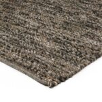 Close-up van de hoek en de rand van het Verona ST Brown Grey 940 200x300 vloerkleed, met het geweven grijze en bruine dessin tegen een witte achtergrond.