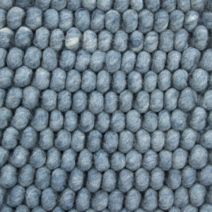 Close-up van het New Loop 227 Sky Blue 200x300 vloerkleed, met dicht opeengepakte, ronde blauwgrijze vilten ballen in een rasterpatroon. Zichtbare wolvezels zorgen voor een zachte, donzige textuur.