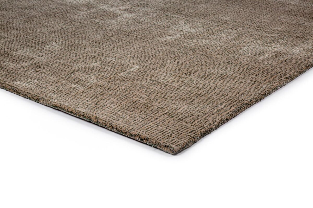 Close-up van de hoek van het rechthoekige vloerkleed Rome Green 06 200x300, met een bruin oppervlak met textuur en een subtiel patroon tegen een witte achtergrond.