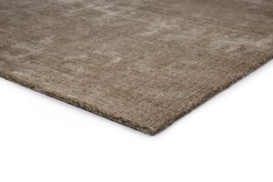 Close-up van de hoek van het rechthoekige vloerkleed Rome Green 06 200x300, met een bruin oppervlak met textuur en een subtiel patroon tegen een witte achtergrond.
