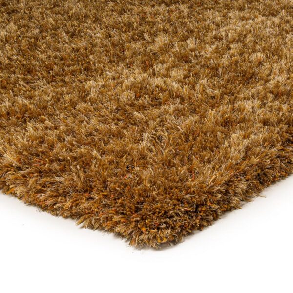 Close-up van de hoek van het New Paulo Gold 030 170x230 pluche bruine shaggy vloerkleed op een witte achtergrond.