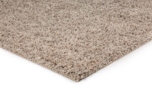 Een close-up van de hoek van het Berbero Lungo Beige 101 200x300 hoogpolig pluche tapijt tegen een witte achtergrond.