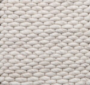 Close-up van Genua Cloud White 815 (200x300), met dikke, zachte witte wolvezels geweven in een horizontaal structuurpatroon. Het dikke, knusse materiaal is ideaal als vloerkleed of deken.