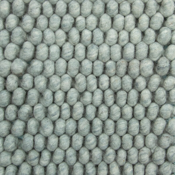 Close-up van New Loop 428 Mint Green 170x230 met een zacht, wollig oppervlak van dicht opeengepakte, ronde vilten bolletjes in een lichtgrijs rasterpatroon.