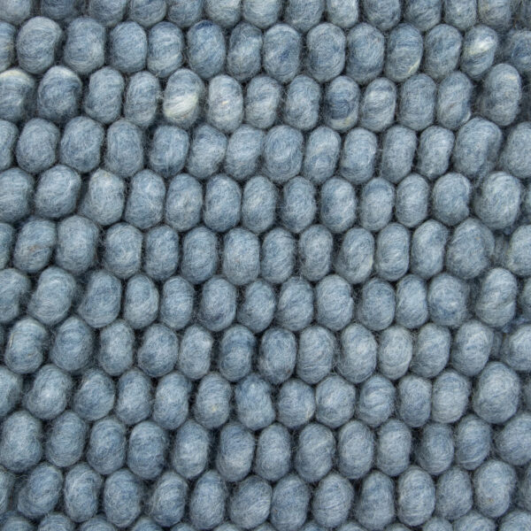 Close-up van de New Loop 227 Sky Blue 170x230: een gestructureerd oppervlak met kleine, ronde, blauwgrijze vilten bolletjes in een rasterpatroon.
