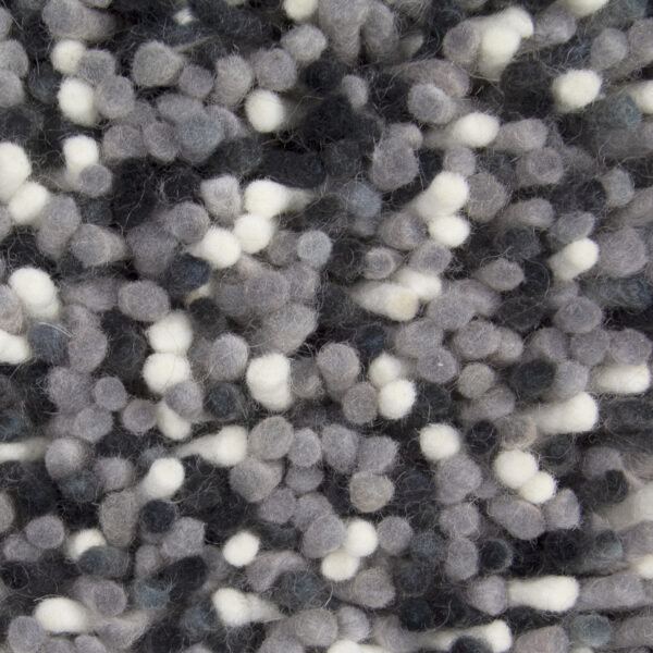 Close-up van de Alto Dolphin 875 170x230, met een gestructureerde stof met geclusterde wollen plukjes in grijs, zwart en wit, waardoor een zacht en hobbelig oppervlaktepatroon ontstaat.
