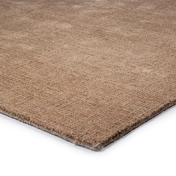 Close-up van de hoek van het vloerkleed Rome Beige 02 170x230, met een zachte, vlakke textuur en subtiel geweven patroon in beige, tegen een witte achtergrond.