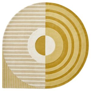 De Fano Girare Wild Wonder ø320 is een rond tapijt dat in tweeën is gesplitst: de ene zijde toont concentrische mosterdgele cirkels, de andere horizontale beige en witte strepen, beide verbonden door een centrale cirkel die de twee patronen mengt.