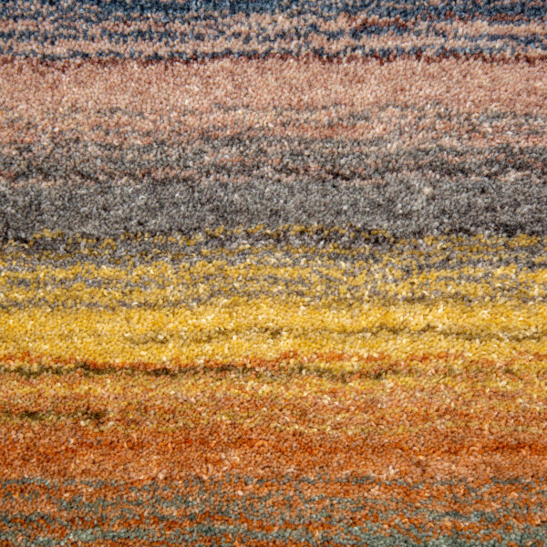 Een close-up van het Portofino Multi 04 200x300 tapijt toont het veelkleurige gestructureerde oppervlak met horizontale strepen in blauw, grijs, geel, oranje en bruin.
