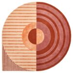 De Fano Girare Lychee ø320 is een rond tapijt met een modern geometrisch ontwerp: de ene helft heeft horizontale strepen in perzik en rood, terwijl de andere helft concentrische cirkels in rood en perzik toont, gecentreerd door een opvallende cirkel.