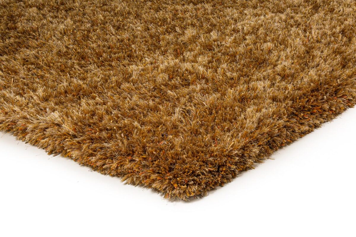 Close-up van het bruine shaggy vloerkleed New Paulo Gold 030 200x300, met de nadruk op de dikke, pluche vezels en textuur, met een hoek tegen een effen witte achtergrond.