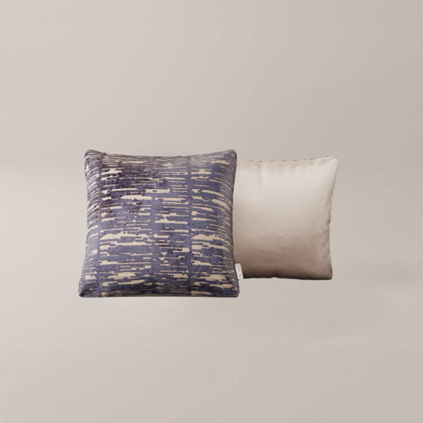Het Indigo sierkussen heeft een abstract blauw en beige patroon met textuur naast een effen lichtbeige kussen met een glad oppervlak, beide op een neutrale achtergrond.