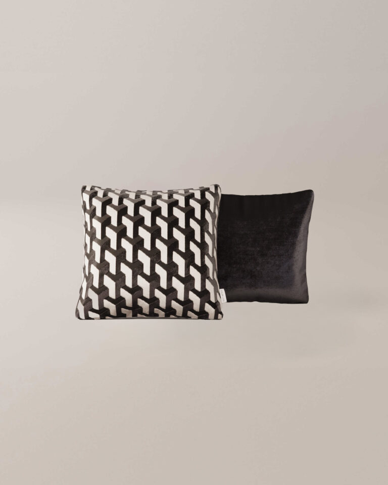 Twee vierkante Lunar-kussens - de ene met een gedurfd zwart-wit geometrisch patroon, de andere effen zwart met een fluweelachtige textuur - worden getoond op een effen lichte achtergrond.