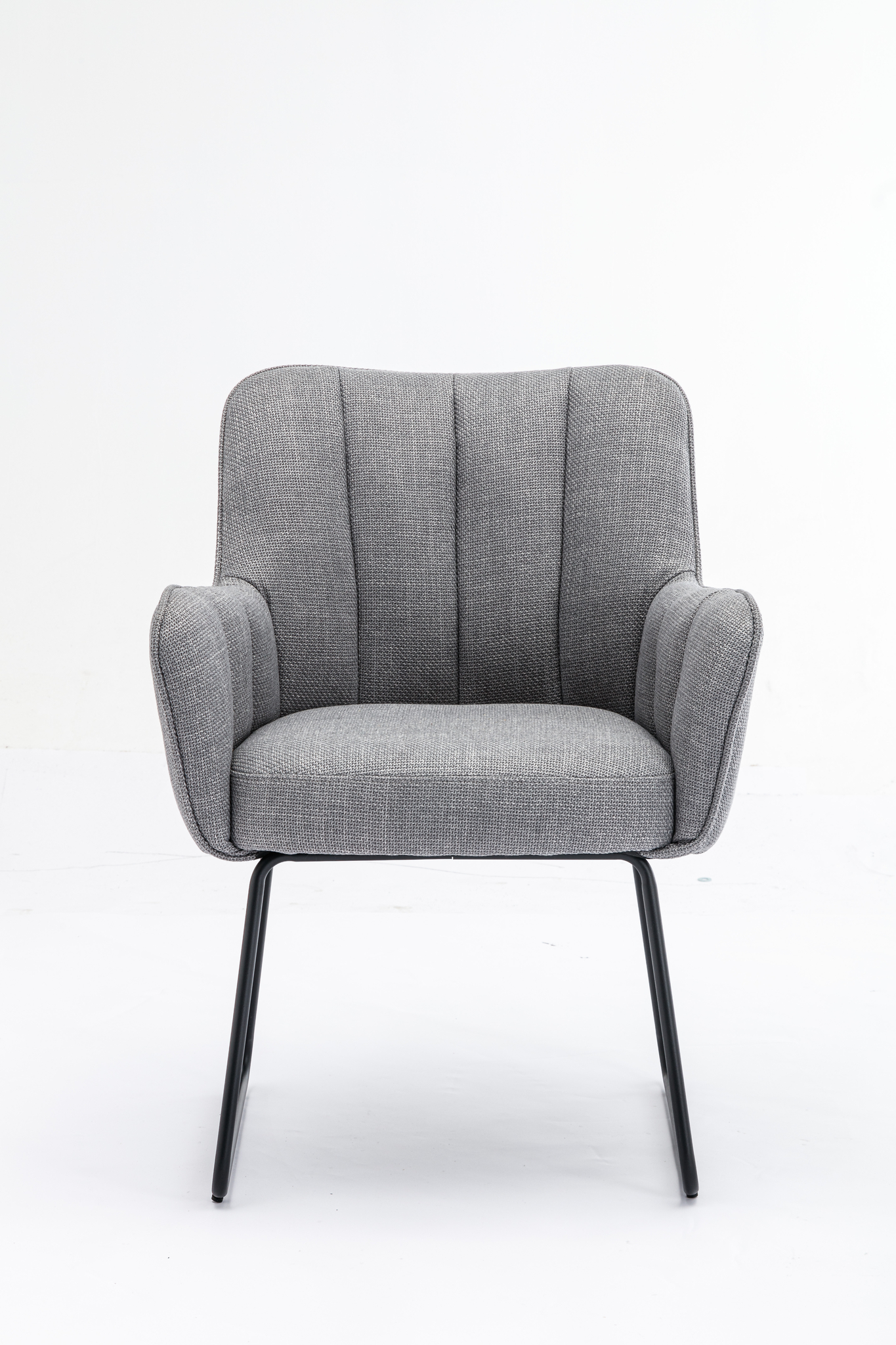 De Stoel Kevin Bjorn Fabric Light Grey is een modern gestoffeerde fauteuil met zwarte metalen poten, gebogen rugleuning en armleuningen, tegen een effen witte achtergrond.