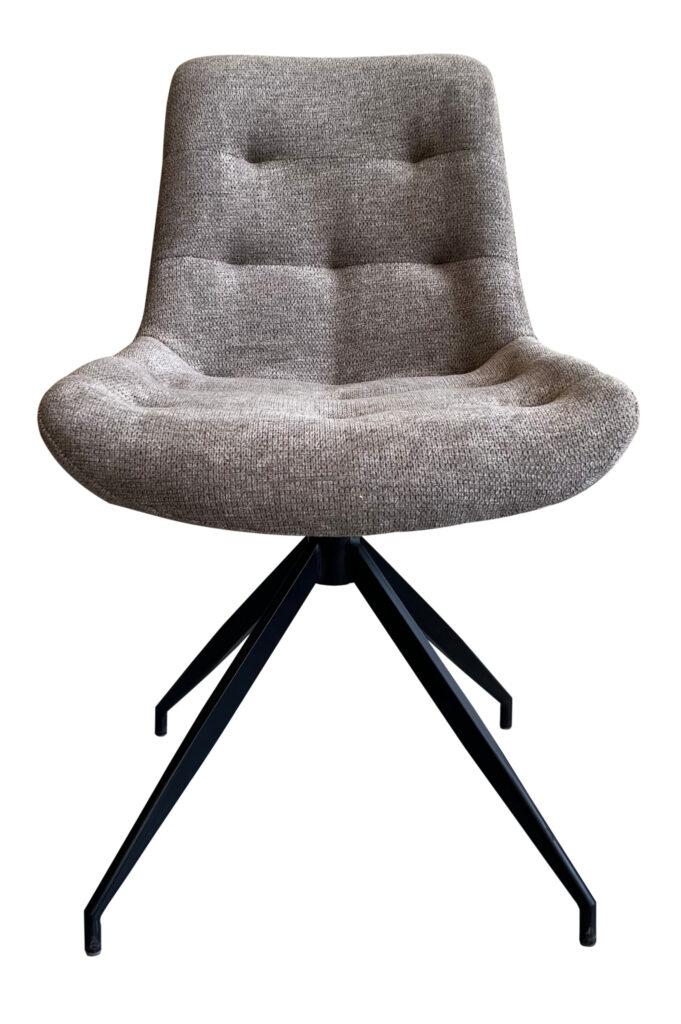 De Stoel Ella Brego Warm Grey is een moderne loungestoel met een beklede zitting en rugleuning in beige stof met textuur, subtiele knopen en vier zwarte metalen poten in een gespreid driepootvormig onderstel.