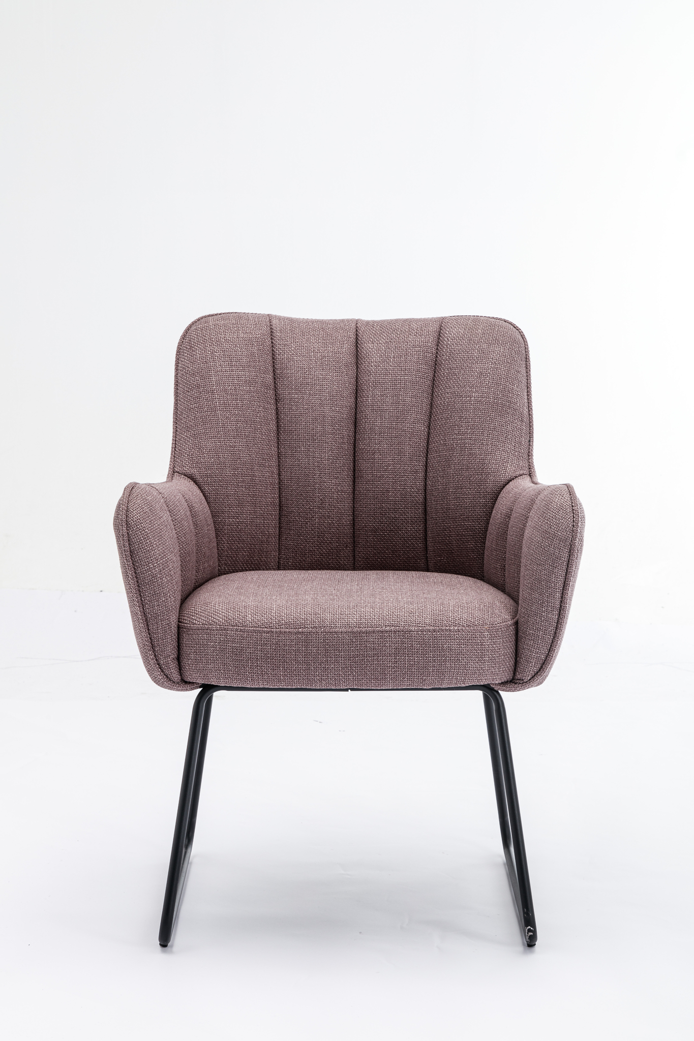 De Stoel Kevin Bjorn Fabric Lavender fauteuil heeft een gestructureerde lavendelkleurige bekleding, gebogen armleuningen, verticale stiksels op de rugleuning en slanke zwarte metalen poten, tegen een effen witte achtergrond.