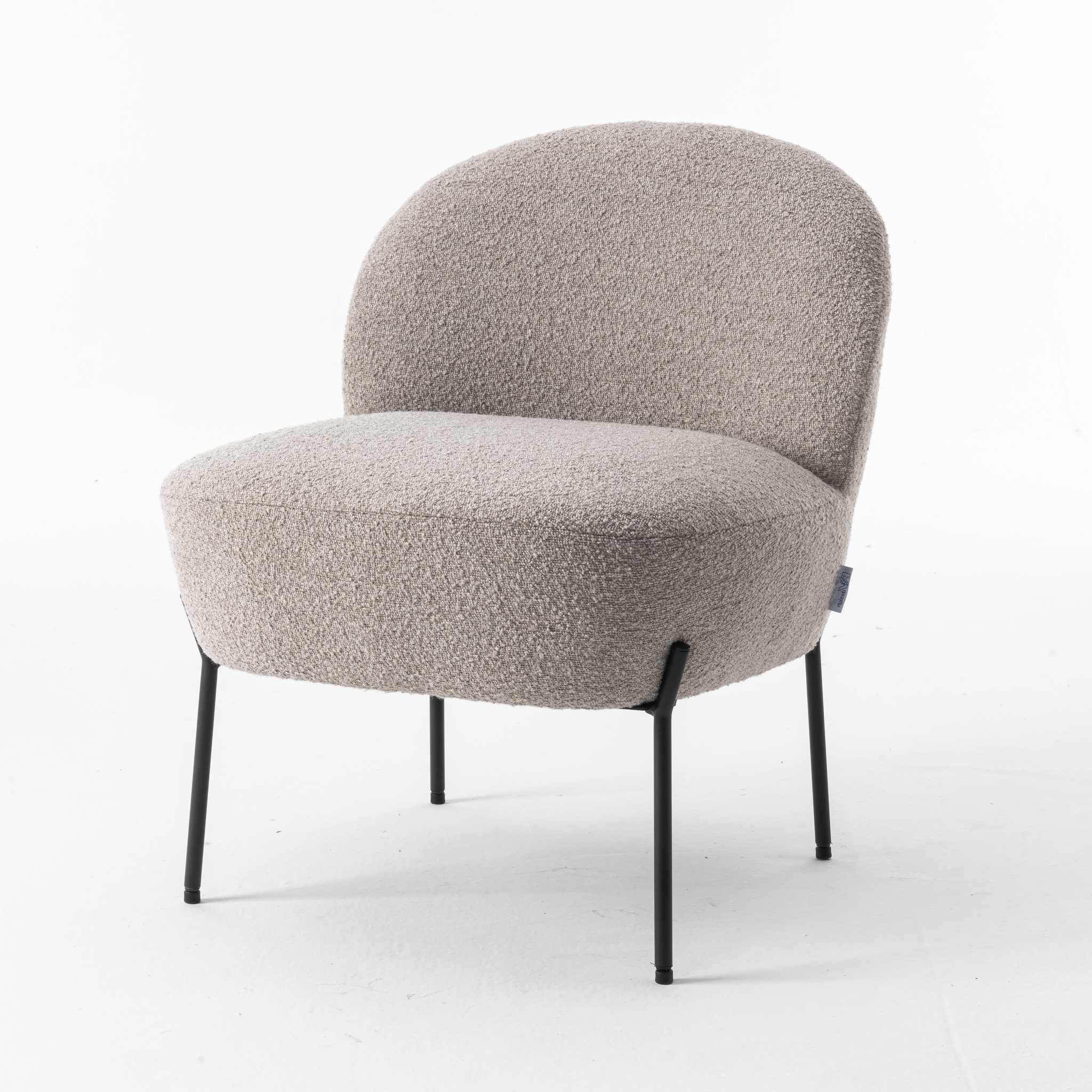 De Baudin fauteuil Stof Teddy Natural 01 is een moderne accentstoel met een afgeronde rugleuning en zitting, bekleed met lichtbeige structuurstof en ondersteund door slanke zwarte metalen poten tegen een witte achtergrond.