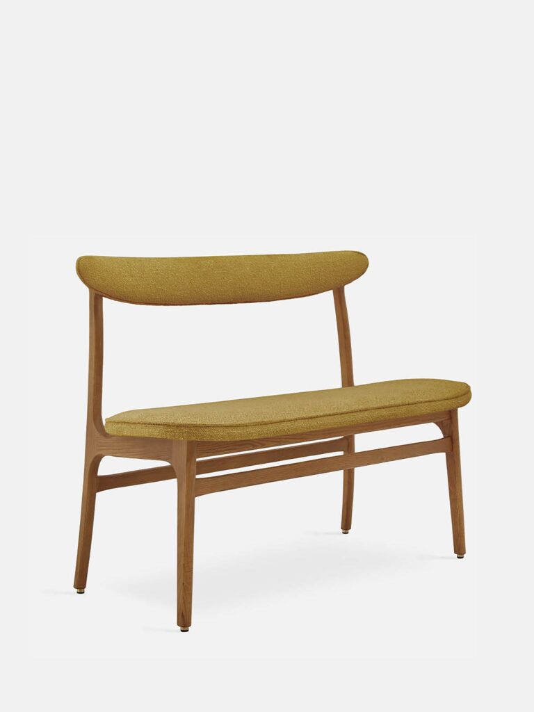 De 200-190 Bank Boucle Mustard Dark Wood heeft een mid-century modern ontwerp met een gebogen mosterdgele gestoffeerde zitting en rugleuning, slanke donkerhouten poten en een minimalistische stijl, tegen een effen witte achtergrond.